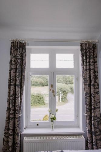 a window with a vase of flowers in front of it at Leygreen Farmhouse B&B in Beaulieu