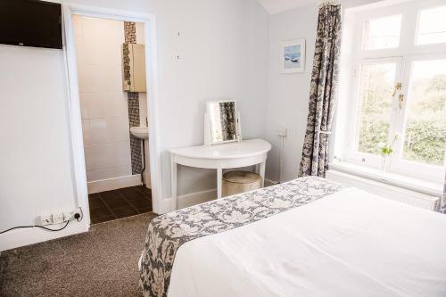 a bedroom with a bed and a sink and a window at Leygreen Farmhouse B&B in Beaulieu