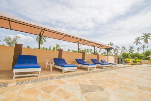 a row of blue chairs on a patio at Havillah Gardens Watamu in Watamu