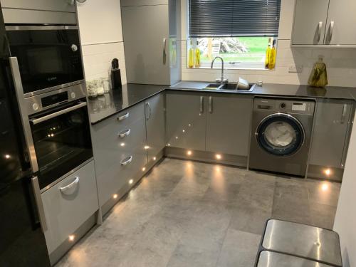 a kitchen with a washing machine and a dishwasher at Littleton Farm Barns in Saham Toney