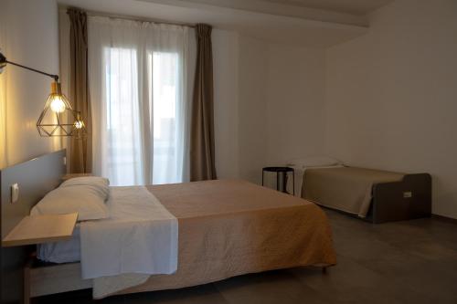 a hotel room with two beds and a window at Olympus in Avola