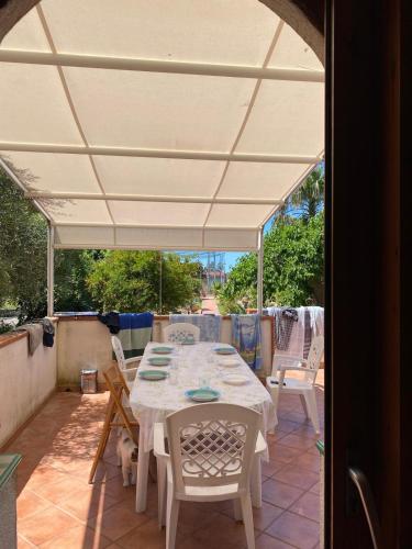 a table and chairs under an umbrella on a patio at La Lampara sul Mare in Torrenova