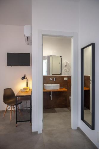 a bathroom with a sink and a desk and a mirror at Olympus in Avola
