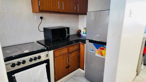 a small kitchen with a stove and a refrigerator at Penthouse Living Mombasa in Mombasa