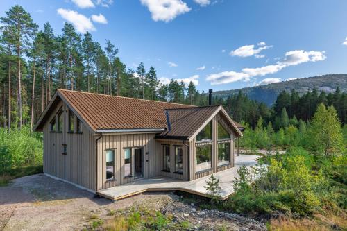a small house in the middle of a forest at Det Kosekroken – Nordic Style Holiday Home by the Fjord in Vradal
