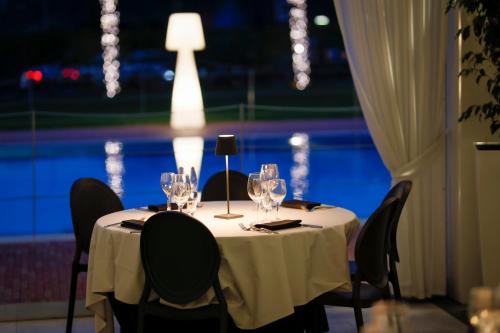 a table with wine glasses and a view of a pool at MICHELINO 75 by the Sydney Hotel in Bologna