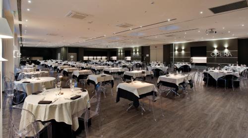 a dining room with tables and chairs with white tablecloths at MICHELINO 75 by the Sydney Hotel in Bologna