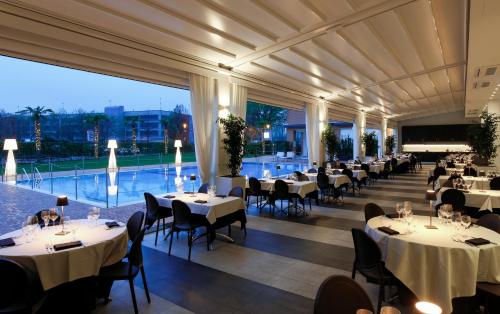 a restaurant with white tables and chairs and a large window at MICHELINO 75 by the Sydney Hotel in Bologna