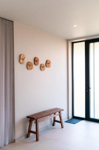a room with a bench and three hats on the wall at VAKANTIEDOMEIN DOUVE in Heuvelland