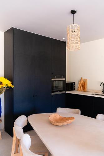 a kitchen with a white table and some chairs at VAKANTIEDOMEIN DOUVE in Heuvelland