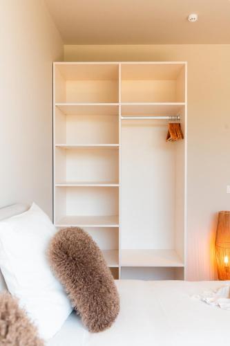 a bedroom with a white bed and a closet at VAKANTIEDOMEIN DOUVE in Heuvelland
