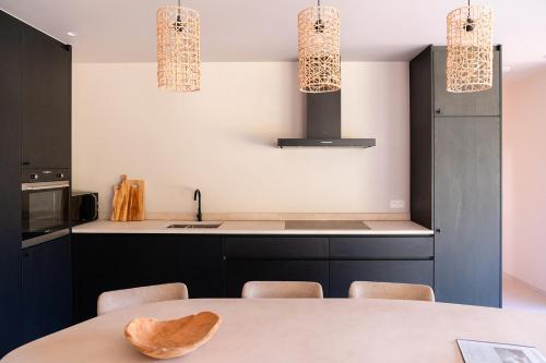 a kitchen with black cabinets and a table with chairs at VAKANTIEDOMEIN DOUVE in Heuvelland