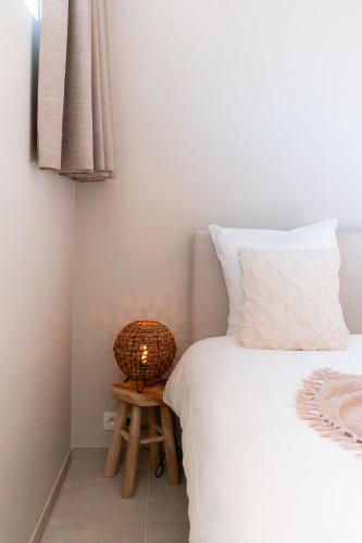 a bed with a lamp on a stool next to it at VAKANTIEDOMEIN DOUVE in Heuvelland