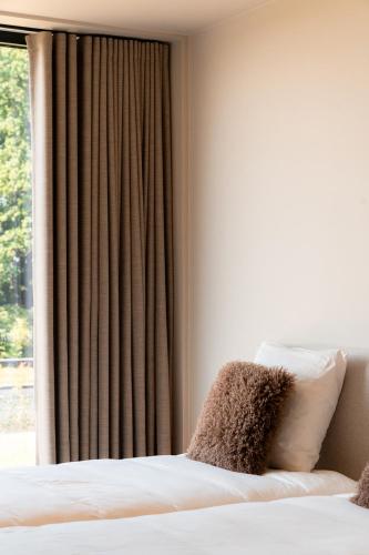 a hotel room with a bed and a window at VAKANTIEDOMEIN DOUVE in Heuvelland