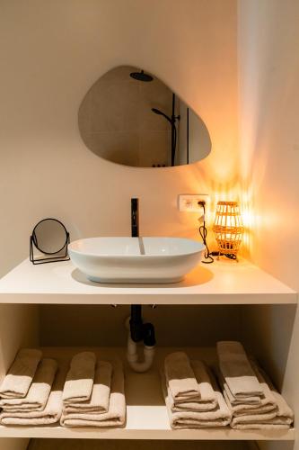 a bathroom with a sink and a mirror and towels at VAKANTIEDOMEIN DOUVE in Heuvelland