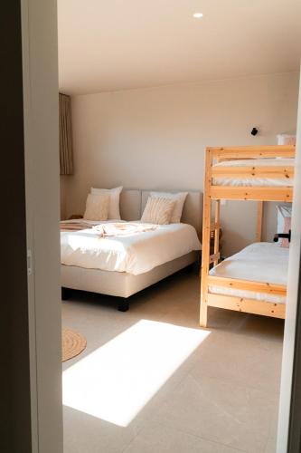 a bedroom with two beds and a bunk bed at VAKANTIEDOMEIN DOUVE in Heuvelland