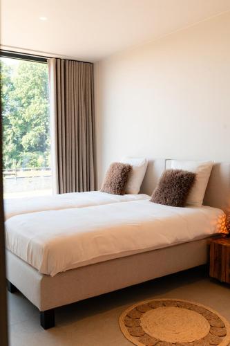 a bedroom with a large bed with a window at VAKANTIEDOMEIN DOUVE in Heuvelland