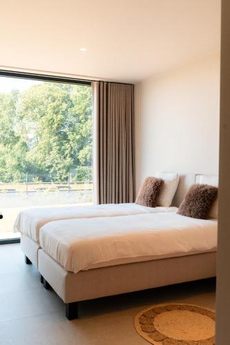 a bedroom with a large bed with a large window at VAKANTIEDOMEIN DOUVE in Heuvelland