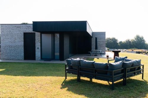 a couch sitting in the grass in front of a building at VAKANTIEDOMEIN DOUVE in Heuvelland