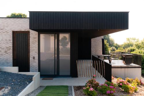 a house with a glass door and a balcony at VAKANTIEDOMEIN DOUVE in Heuvelland