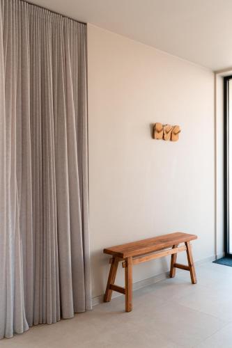 a room with a wooden bench next to a curtain at VAKANTIEDOMEIN DOUVE in Heuvelland