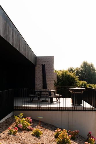 a building with a patio with a table and chairs at VAKANTIEDOMEIN DOUVE in Heuvelland