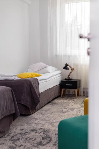 a bedroom with a bed and a table with a lamp at Hotel Nafta Krosno in Krosno
