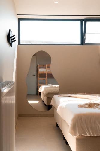 a room with three beds and a window at VAKANTIEDOMEIN DOUVE in Heuvelland