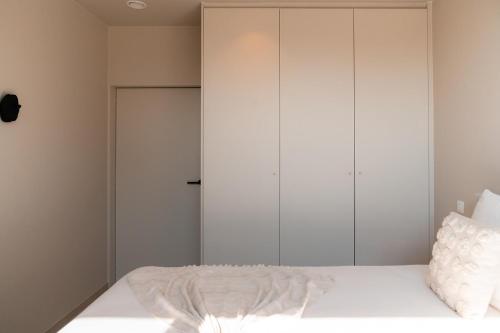 a bedroom with a bed with white cabinets at VAKANTIEDOMEIN DOUVE in Heuvelland