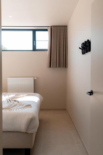 a bedroom with a bed and a window at VAKANTIEDOMEIN DOUVE in Heuvelland