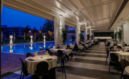 a banquet hall with tables and chairs and a pool at MICHELINO 75 by the Sydney Hotel in Bologna