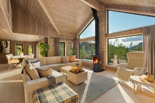 a living room with a couch and a fireplace at Det Kosekroken – Nordic Style Holiday Home by the Fjord in Vradal