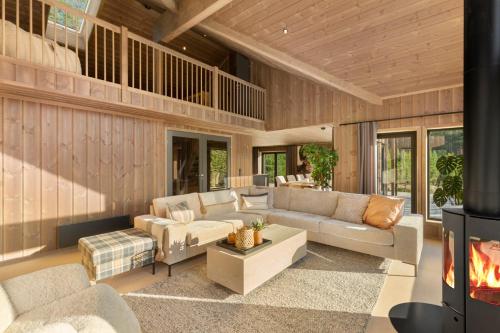 a living room with a couch and a fireplace at Det Kosekroken – Nordic Style Holiday Home by the Fjord in Vradal