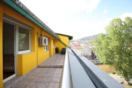 a yellow building with a balcony with a view at Amazing Penthouse old town in Sarajevo