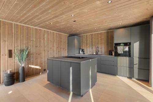 a kitchen with wooden walls and a wooden ceiling at Det Kosekroken – Nordic Style Holiday Home by the Fjord in Vradal