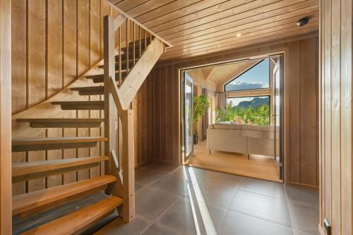 a wooden staircase in a house with a large window at Det Kosekroken – Nordic Style Holiday Home by the Fjord in Vradal