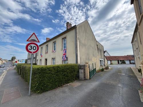 a street sign in front of a building at Les continents maison spacieuse 4 belles chambres parking privatif terrasse à 5 mn à pied tous commerces et 20 mn plage Omaha Beach et à 15 mn de Bayeux in Le Molay-Littry