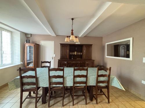 a dining room with a table and chairs at Les continents maison spacieuse 4 belles chambres parking privatif terrasse à 5 mn à pied tous commerces et 20 mn plage Omaha Beach et à 15 mn de Bayeux in Le Molay-Littry