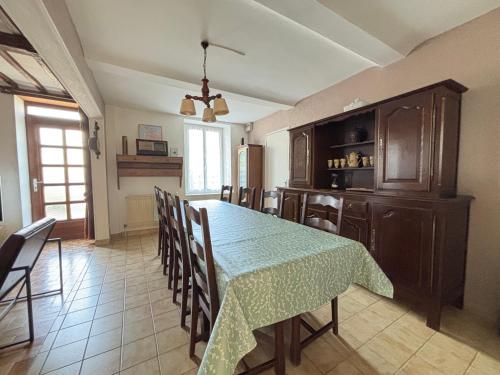 a kitchen and dining room with a table and chairs at Les continents maison spacieuse 4 belles chambres parking privatif terrasse à 5 mn à pied tous commerces et 20 mn plage Omaha Beach et à 15 mn de Bayeux in Le Molay-Littry