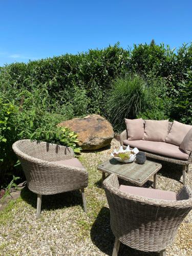 a patio with two chairs and a table and a couch at Moderne Ferienwohnung Nähe Bad Griesbach, Haarbach in Haarbach