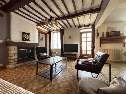 a living room with a table and a fireplace at Les continents maison spacieuse 4 belles chambres parking privatif terrasse à 5 mn à pied tous commerces et 20 mn plage Omaha Beach et à 15 mn de Bayeux in Le Molay-Littry
