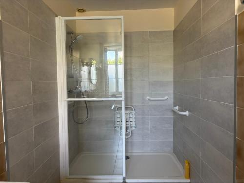 a shower with a glass door in a bathroom at Les continents maison spacieuse 4 belles chambres parking privatif terrasse à 5 mn à pied tous commerces et 20 mn plage Omaha Beach et à 15 mn de Bayeux in Le Molay-Littry