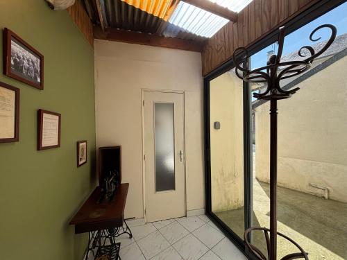 a room with a hallway with a door and a window at Les continents maison spacieuse 4 belles chambres parking privatif terrasse à 5 mn à pied tous commerces et 20 mn plage Omaha Beach et à 15 mn de Bayeux in Le Molay-Littry
