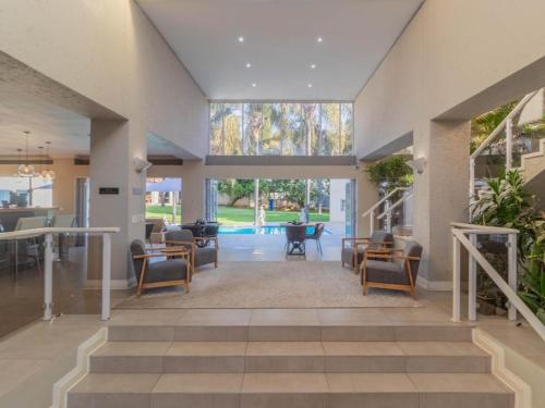 a living room with a staircase and a lobby with chairs at Villa Reis - The Villa of Kings Hotel & Spa in Bedfordview