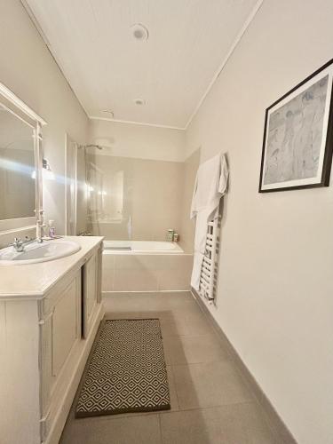 une salle de bain blanche avec un lavabo et une baignoire dans l'établissement Ty Traez, holiday house for families in Cap Sizun, à Primelin