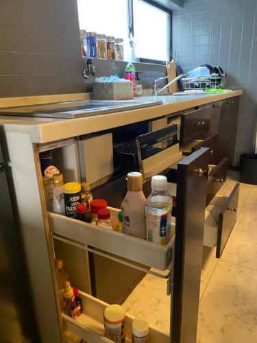 a kitchen with a sink and an open refrigerator at 橘の郷 ORANGE inn Tengachaya in Osaka