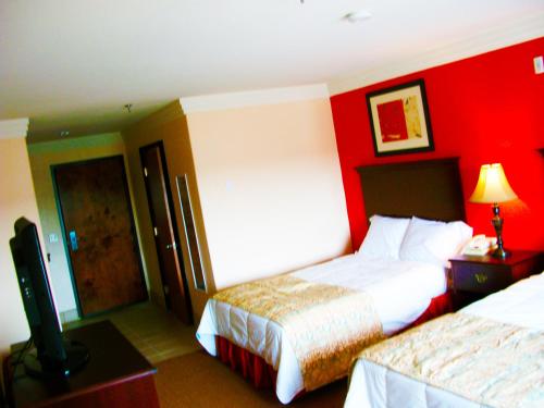 a hotel room with two beds and a flat screen tv at Robinson Inn and Suites in Robinson