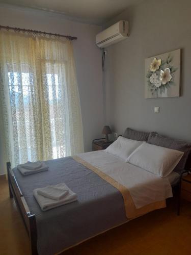 a bedroom with a bed with two towels on it at Platouka's House in Ágios Matthaíos