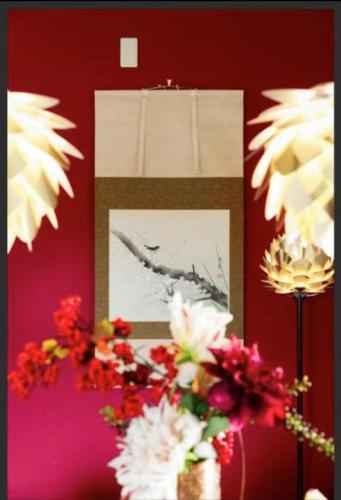 a picture of flowers on a wall with a picture at 橘の郷 ORANGE inn Tengachaya in Osaka