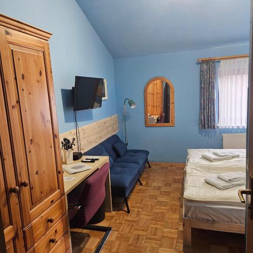 a bedroom with a desk and a bed and a blue room at Schwarzwald Sportzentrum Neubulach in Neubulach